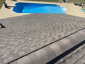 A shingled roof with a nearby swimming pool in a backyard setting.